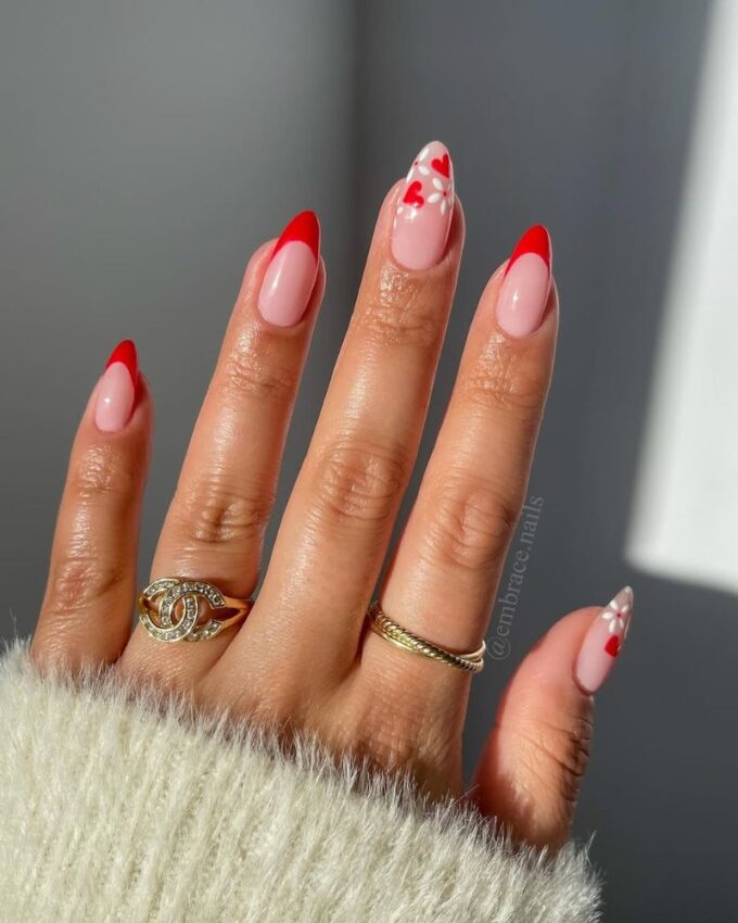 Ongles French rouges élégants avec des cœurs et des fleurs blanches