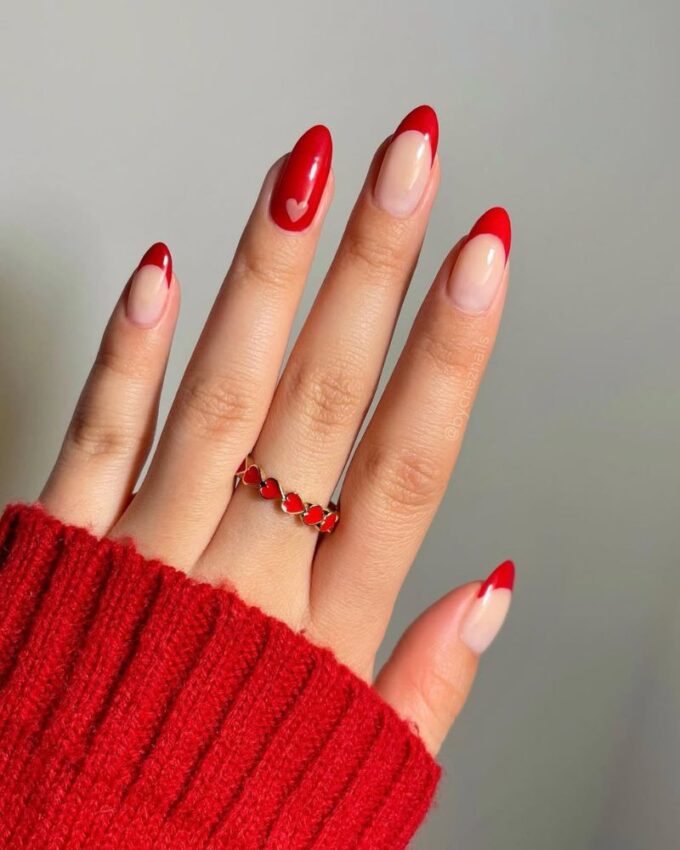 Manucure rouge avec un nail art en forme de cœur minimaliste