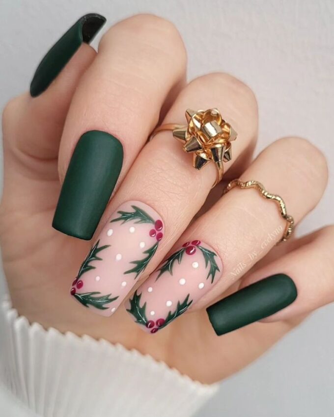 Manucure en vert foncé avec un nail art de gui pour un look chic et festif