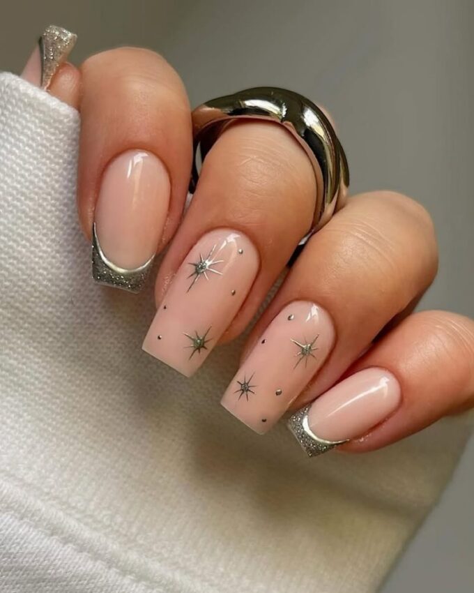 Design d’ongles hivernal avec flocons de neige scintillants, parfait pour un look raffiné.