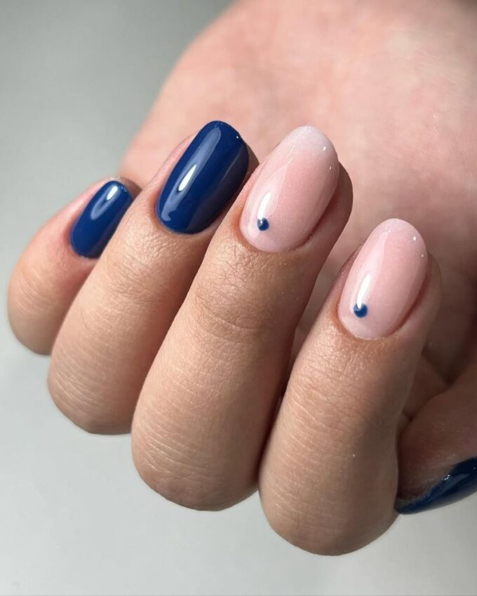 Manucure bleu foncé équilibrée par une base nude