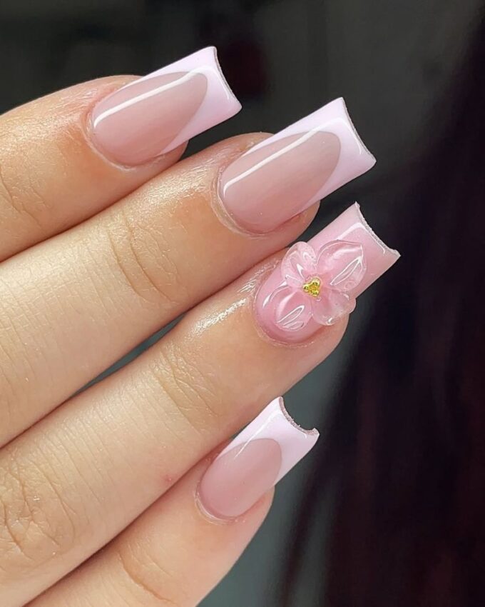 Ongles French avec une base rose clair et des fleurs 3D transparentes