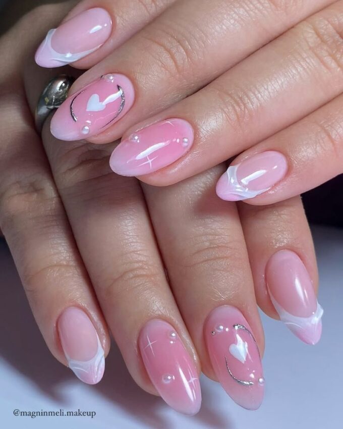 Manucure naturelle en rose clair avec une touche brillante sur ongles en amande