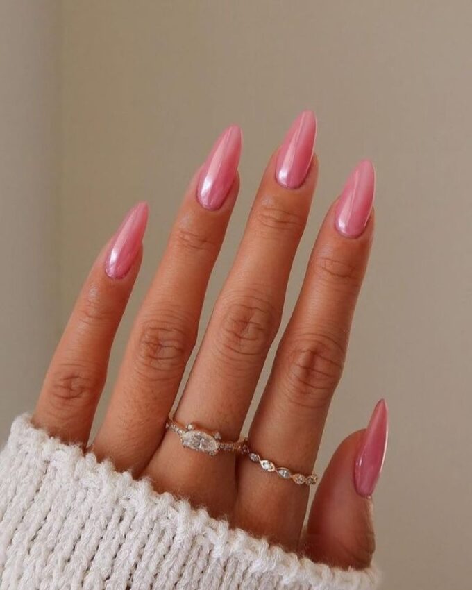 Manucure rose clair chromée avec une finition nacrée sur ongles stilettos