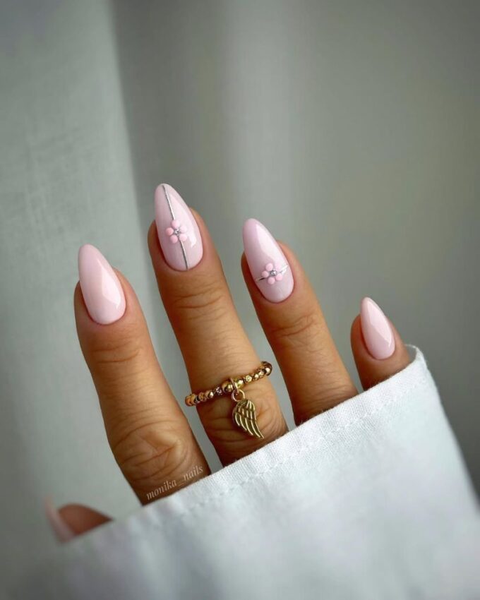 Ongles rose clair avec de petites fleurs roses et des lignes argentées