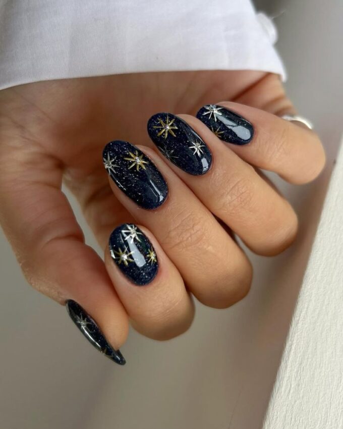 Ongles bleu scintillant avec des étoiles dorées et argentées pour un look romantique