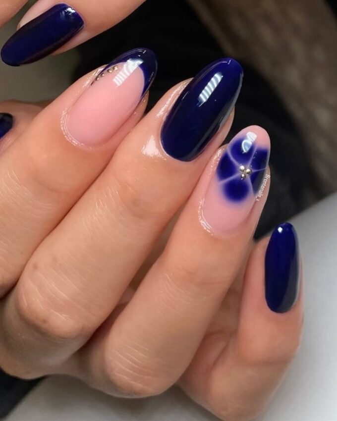 Ongles bleu foncé avec des motifs floraux et un design French élégant