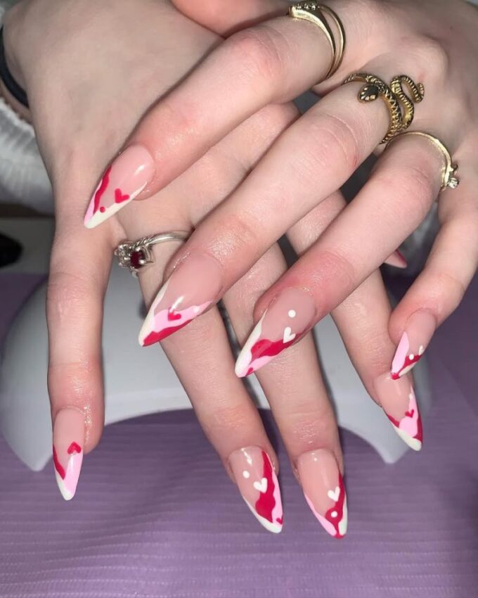 Ongles stiletto roses avec deux teintes et un design ludique.